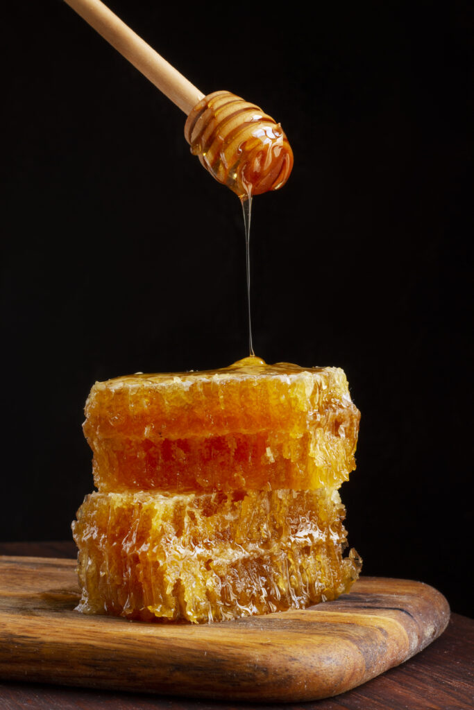 front-view-honey-dipper-dripping-honey-honeycomb